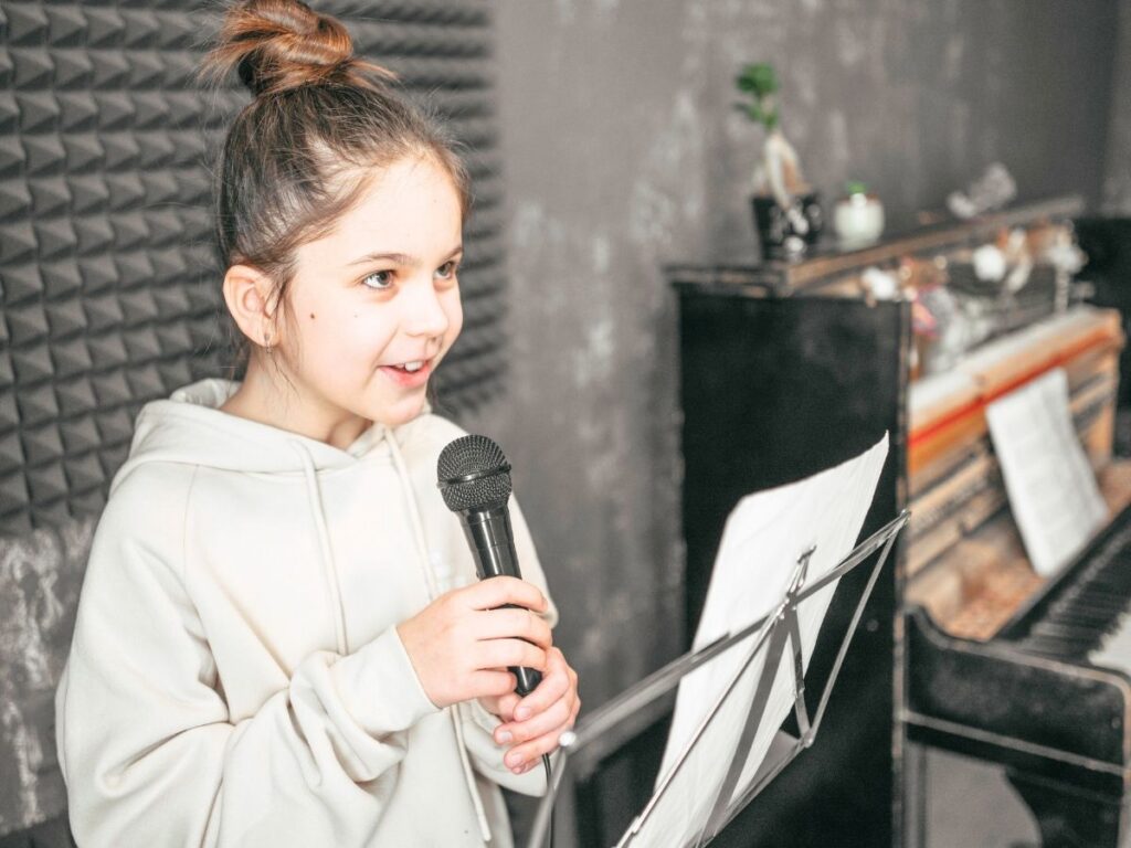 Jeune chanteuse au micro lors d’un atelier de chant et de coaching vocal